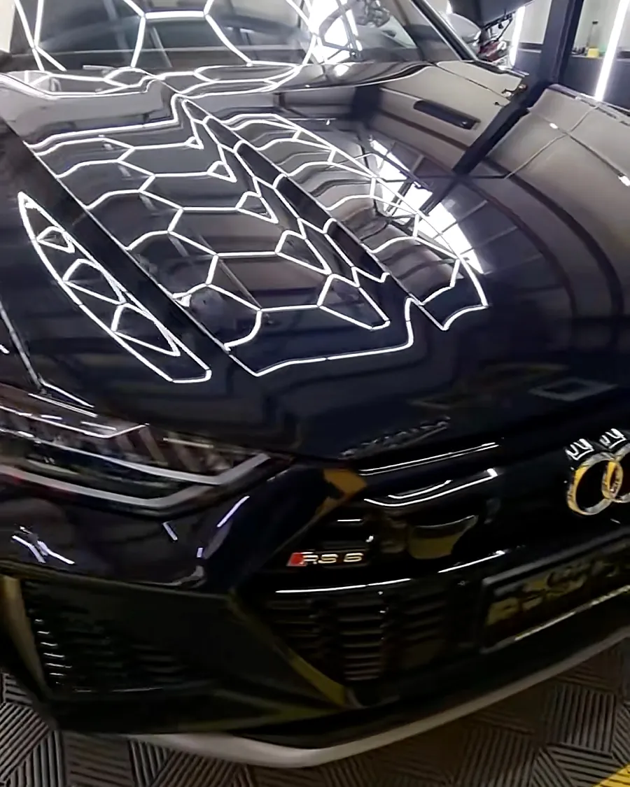 Audi RS 6 negru, cu reflexia grilei hexagonale pe capotă după corecția lacului